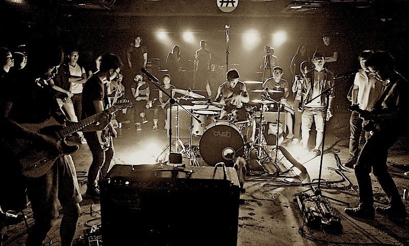 Dicht besetzter Underground-Klub bei einem Livekonzert mit Band und Publikum