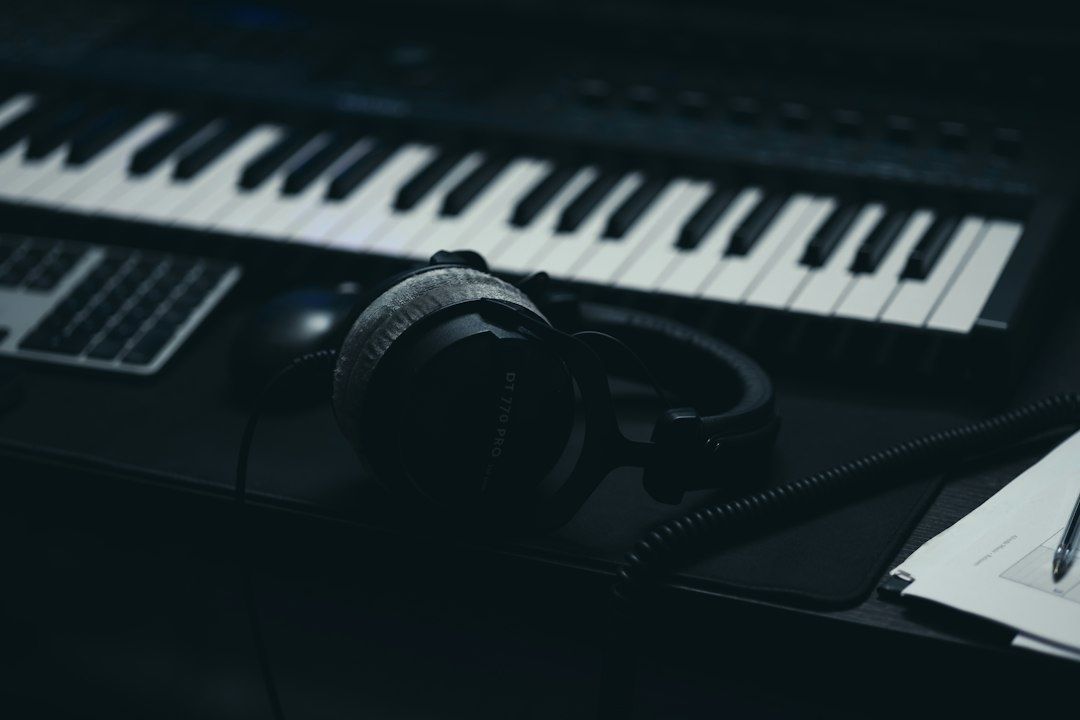 Kopfhörer liegen vor einer Tastatur und einem Laptop im Musikstudio